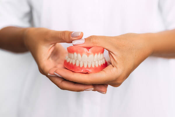 person holding dentures