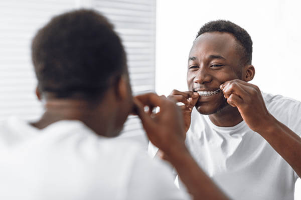 Man flossing in mirror